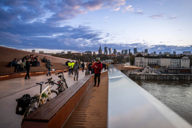 2\Kładka pieszo-rowerowa - ujęcie z kładki na jej użytkowników oraz panoramę Warszawy